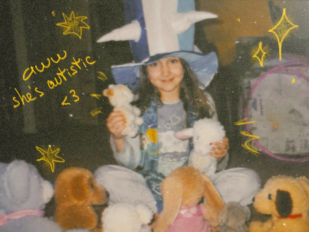 Alisa as a child in a blue wizard hat, holding two toy lambs among a circle of stuffed animals